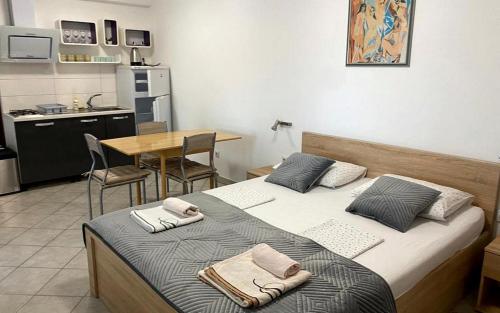 two beds in a room with a kitchen and a table at Apartments Villa Bubi in Pula