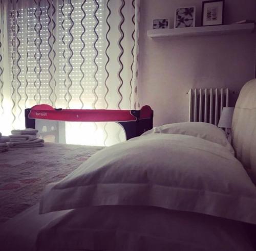 a bedroom with a bed with a red headboard and a window at B&B incentro in Foggia
