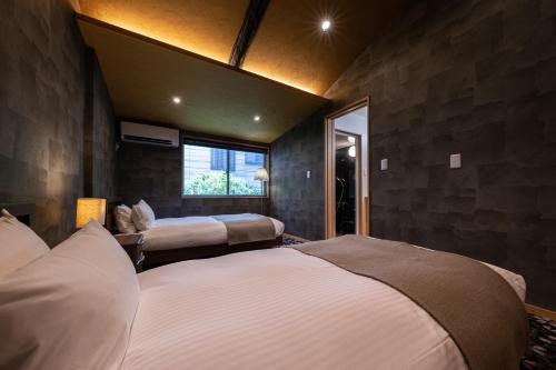 a bedroom with two beds and a window at 京恋 竹林邸 in Kyoto