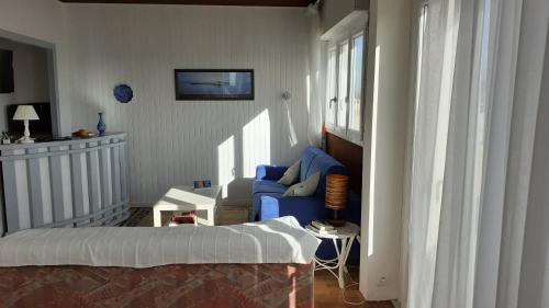 une chambre avec un lit et une chaise bleue dans l'établissement Quartier ARAGO - Appartement spacieux et lumineux, à Les Sables-dʼOlonne