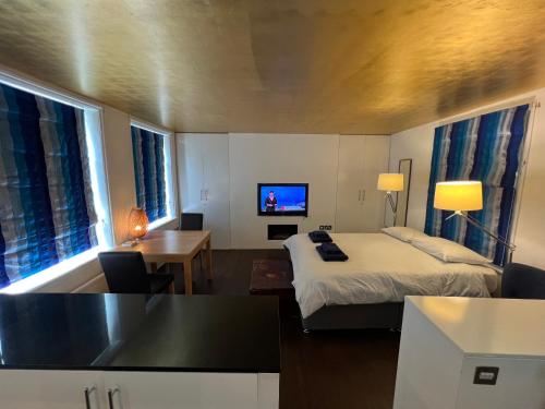 um quarto de hotel com uma cama e uma televisão em Studio Apartment, Covent Garden em Londres