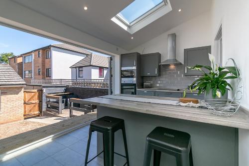a kitchen with a counter and two stools at Archers House in Stevenage