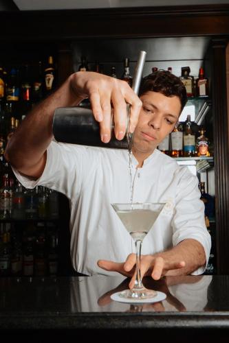 a man pouring a drink into a martini glass at DiplomaticHotel in Mendoza