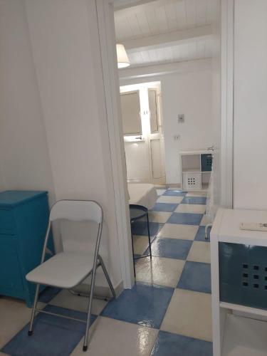 um quarto com uma cadeira e piso azul e branco em Casa Vittoria em Roccella Ionica