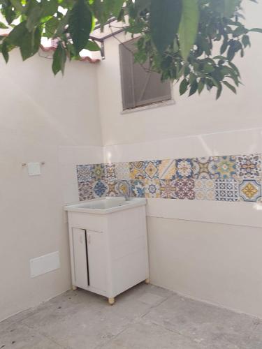 uma casa de banho com um lavatório e uma parede de azulejos em Casa Vittoria em Roccella Ionica