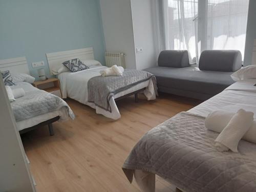 a room with two beds and a couch in it at Pension Xacobeo Lavacolla in Lavacolla
