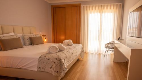 una camera da letto con un grande letto con asciugamani di House J São Rafael - By Bedzy ad Albufeira