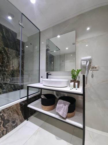 bagno con lavandino e specchio di Fiorzakynthos City Apartments a Città di Zante