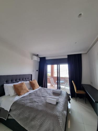 una camera da letto con un grande letto con una grande finestra di Fiorzakynthos City Apartments a Città di Zante