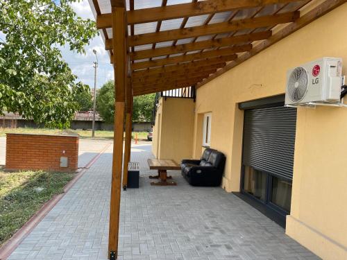 a patio with a bench and a wooden pergola at Casa Sofia in Satu Mare