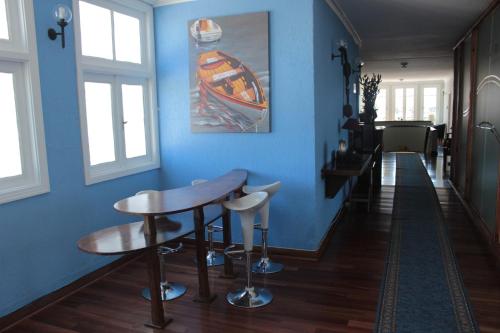 a blue room with a table and two stools at Alhambra Hotel in San Antonio