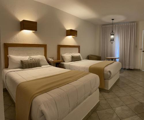 a hotel room with two beds in a room at Aldea del Bazar in Tehuacán