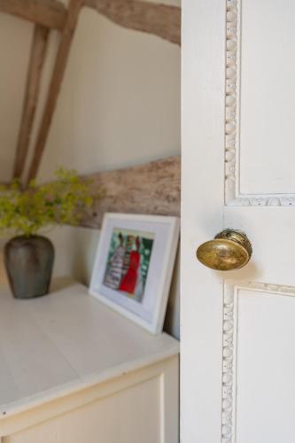 a room with a mirror and a picture on a counter at Boddington Mill, Enchanting 3 Bdr Retreat by Oriri in Cheltenham