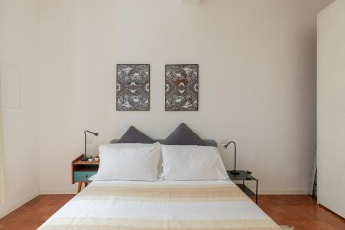 1 dormitorio con 1 cama con 2 cuadros en la pared en iFlat Monti Charming Apartment, en Roma
