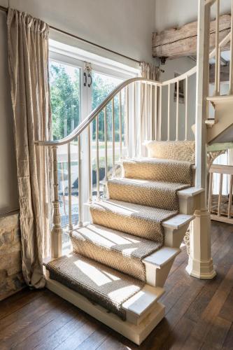 a white staircase in a home with a window at Boddington Mill, Enchanting 3 Bdr Retreat by Oriri in Cheltenham