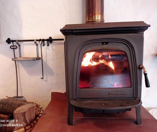 a stove with a fire in a room at Belaustegi turismo rural in Ispáster