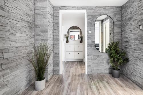 a hallway with a stone wall and a mirror at Luxury 3 Bedroom Apartment in Marylebone in London