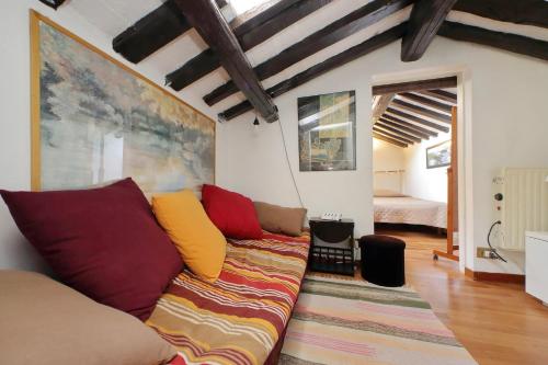 a living room with a couch with colorful pillows at La Dimora Pantheon in Rome