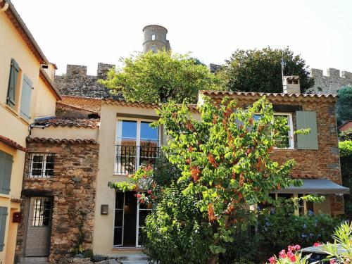 a stone house with a tree in front of it at Pretty Historical Village House in Grimaud