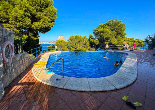 カルプにあるApartamento en cala Manzaneraの水中の人々と一緒にプール