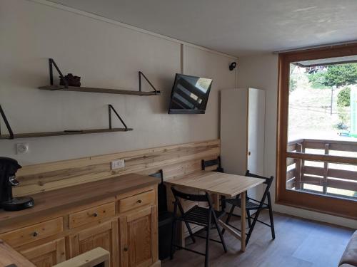 cocina con mesa de madera, escritorio y ventana en Studio rénové centre station Vallandry, en Landry