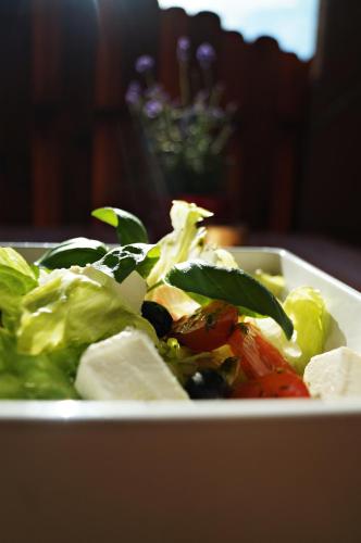 a white bowl of salad with lettuce and tomatoes at Hotel Kresowianka in Konin