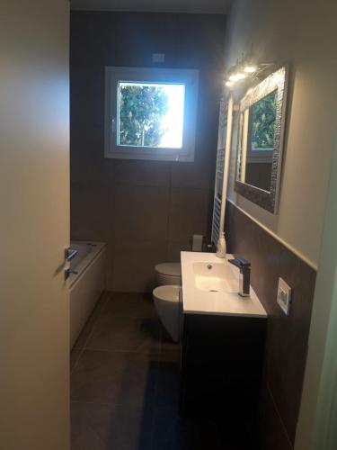 La salle de bains est pourvue d'un lavabo, de toilettes et d'une fenêtre. dans l'établissement Casa Mare, à Misano Adriatico