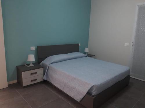 - une chambre avec un lit et une table de chevet avec deux lampes dans l'établissement Casa Mare, à Misano Adriatico