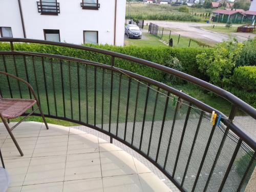 a balcony with a metal railing and a chair at Baltazar in Łeba