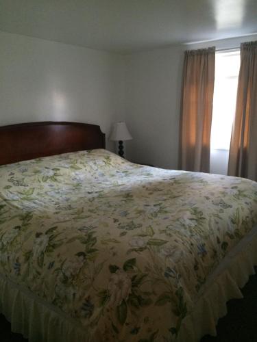 a bedroom with a bed with a floral bedspread at Lodge at Kennebunk in Kennebunk