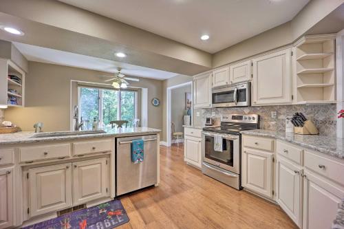 a kitchen with white cabinets and stainless steel appliances at Lakefront Getaway with Private Dock and Kayaks! in Bella Vista
