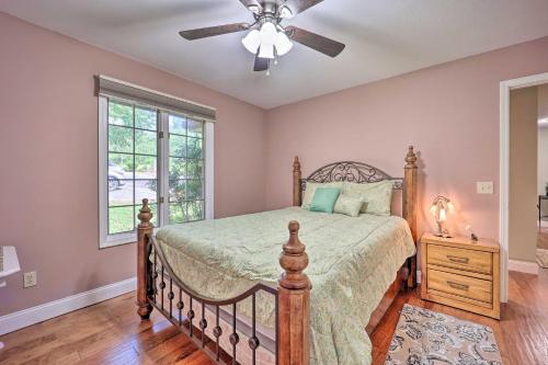 a bedroom with a bed and a ceiling fan at Lakefront Getaway with Private Dock and Kayaks! in Bella Vista