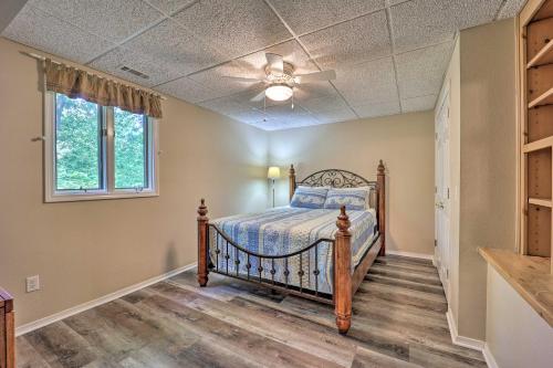 a bedroom with a bed and a ceiling fan at Lakefront Getaway with Private Dock and Kayaks! in Bella Vista