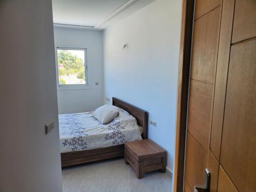 a small bedroom with a bed and a window at Superbe appartement avec vue sur mer in Saïdia