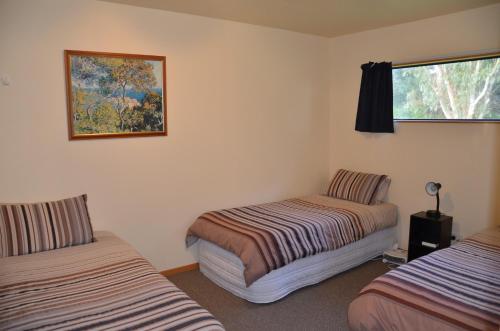 a room with two beds and a picture on the wall at Catlins Newhaven Holiday Park in Owaka