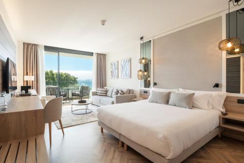 a bedroom with a large bed and a living room at Attica21 Vigo 4 Superior in Vigo