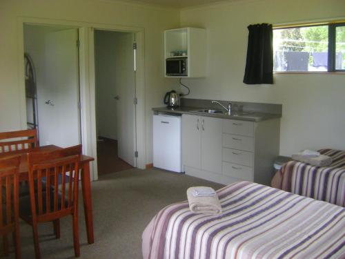 a room with a kitchen and a table and a sink at Catlins Newhaven Holiday Park in Owaka