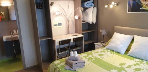 a small bedroom with a bed and a sink at Le Faubourg in Figeac