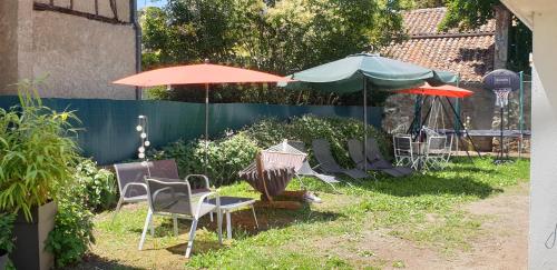 a group of chairs and umbrellas in a yard at Le Faubourg in Figeac