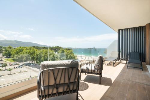 a balcony with chairs and a view of the ocean at Attica21 Vigo 4 Superior in Vigo
