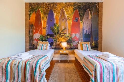 2 letti in una camera con tavole da surf sul muro di Saldanha Charming Palace a Lisbona