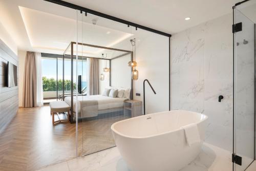 a white bathroom with a tub and a bedroom at Attica21 Vigo 4 Superior in Vigo