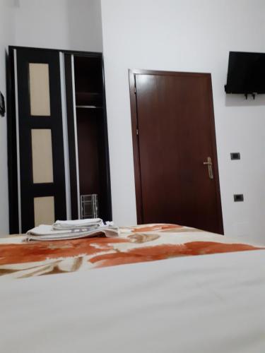a bedroom with a bed and a wooden door at Hotel Shpetimi in Çorovodë