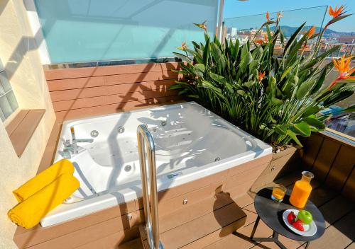 a bath tub sitting on top of a balcony at KAKTUS Hotel Volga - Adults Recommended in Calella