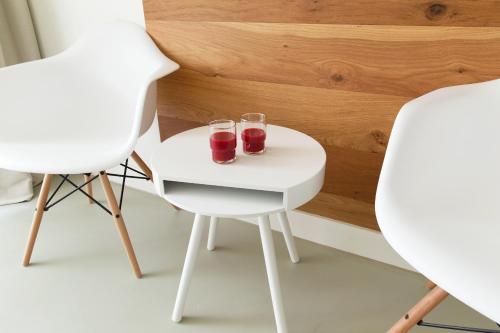 two glasses on a white table between two chairs at Marnix360apartments The Mansion Suites in Amsterdam