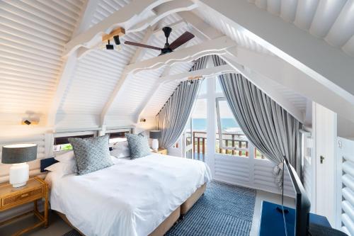 a bedroom with a white bed and a window at Brenton on Sea Chalet in Brenton-on-Sea
