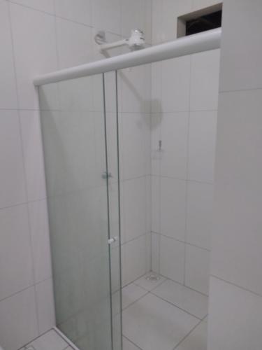 a bathroom with a shower with a glass door at Mandala Hostel Maragogi Oficial in Maragogi