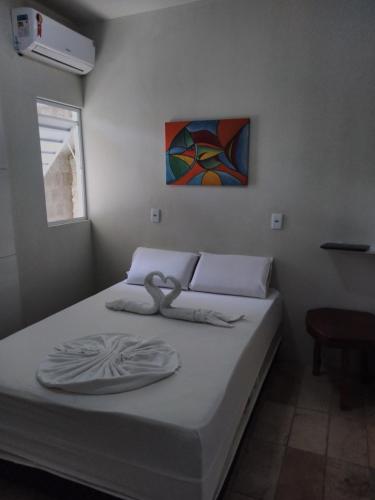 Mandala Hostel Maragogi Oficial في ماراغوغي: سرير في غرفة نوم مع لوحة على الحائط