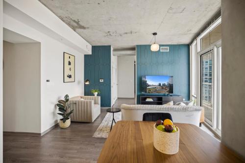a living room with a couch and a tv at Placemakr Premier SoBro in Nashville