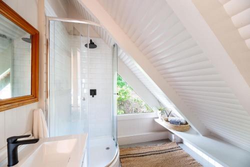 un bagno con doccia e lavandino di Brenton on Sea Chalet a Knysna
